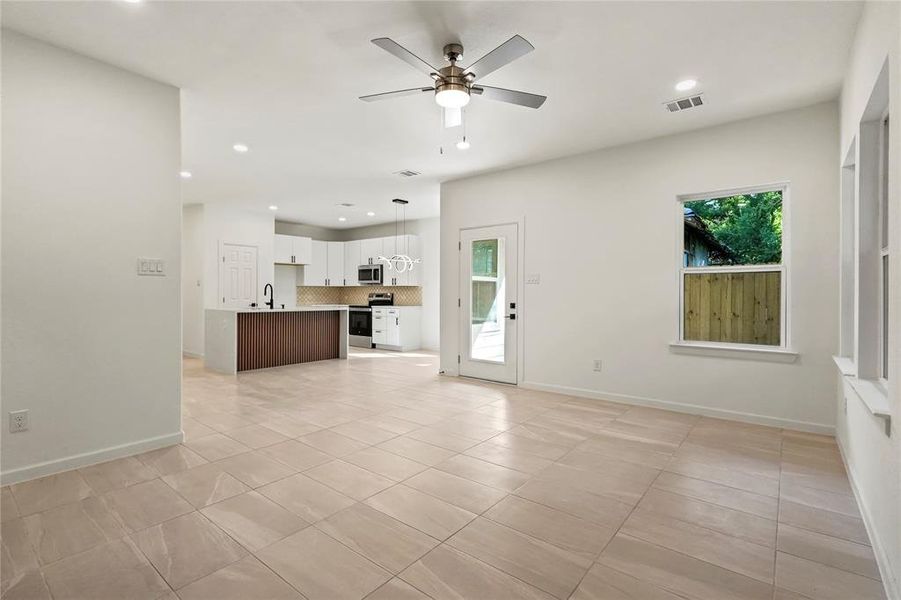 Unfurnished living room featuring light tile patterned floors, recessed lighting, and a ceiling fan