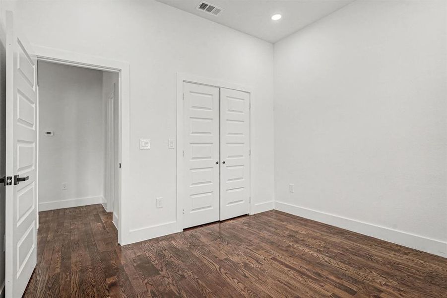 Secondary bedroom featuring hardwood flooring, dual door large closet, lighted ceiling fan and recessed lighting.