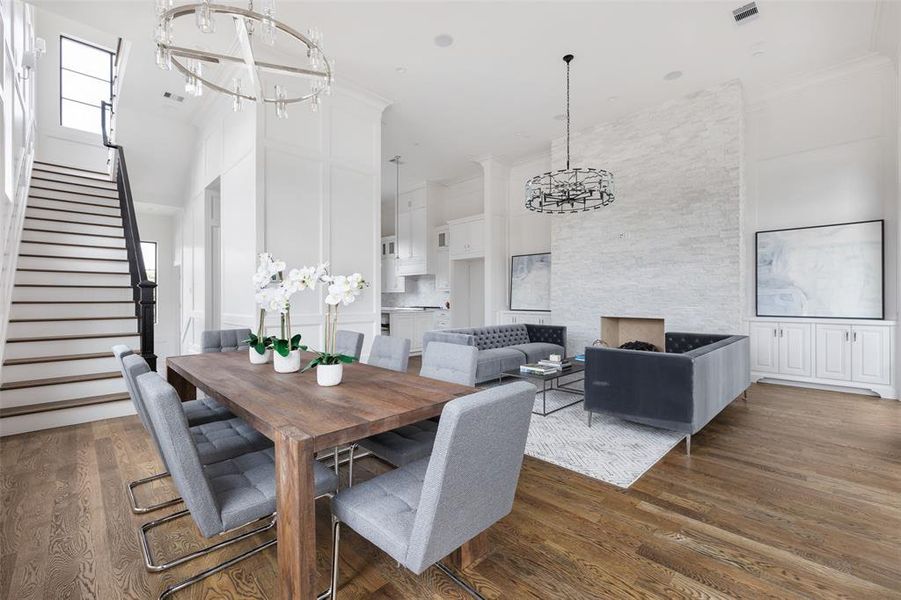 The designated dining room features a statement over-table chandelier and is flanked by large windows and doors. Built with a focus on efficiency, the low E, double pane Milgard windows throughout the home help keep energy costs low. Image from previously completed home in the community.