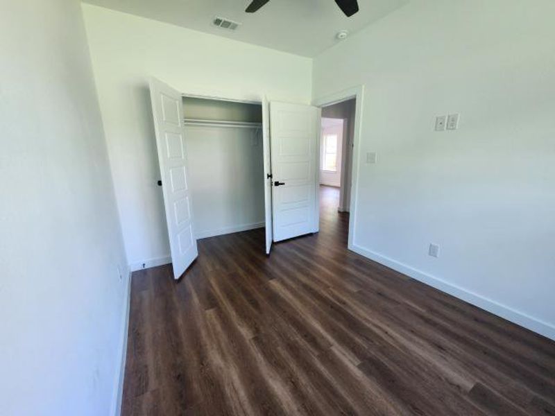 Unfurnished bedroom featuring dark wood-style flooring, a closet, and ceiling fan Unfurnished bedroom featuring dark wood-style flooring, a closet, and ceiling fan