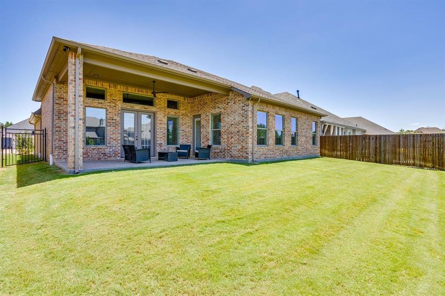 Expansive green lawn bordering a brick exterior with multiple windows