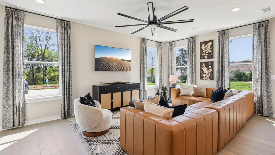 First floor living room with leather couch and large fan