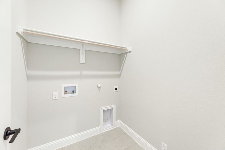 Laundry room with wall-mounted shelf, washer and dryer hookups, gas connection, and tile floor