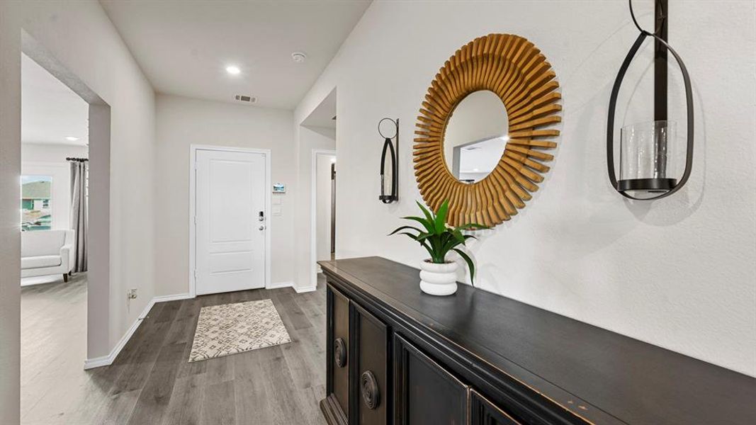 Welcoming entry with light-toned walls, recessed lighting, and durable plank flooring