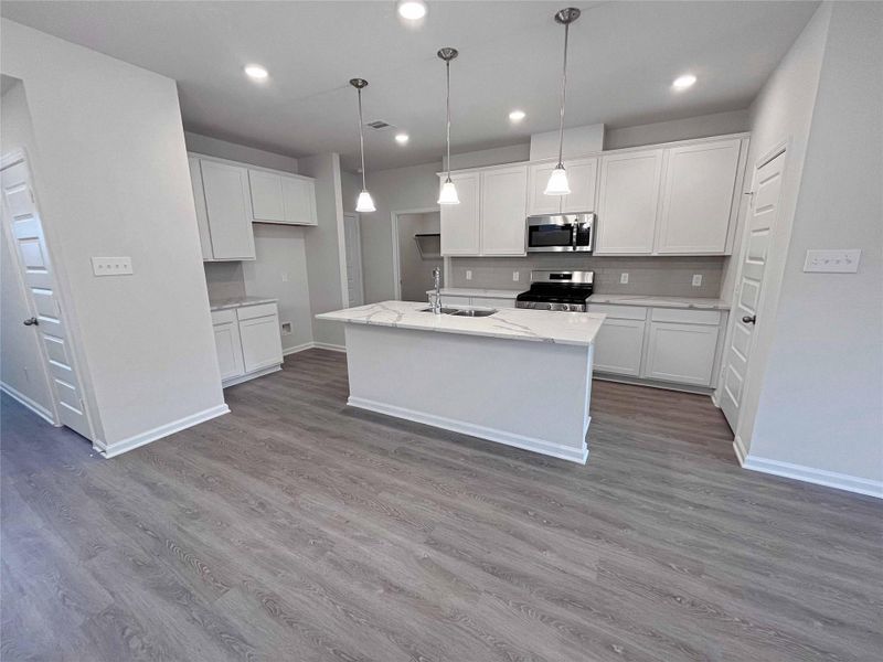 The Robin II- Kitchen with Island and Ample Cabinets. Home under construction. Sample floor plan photo used for illustrative purposes only. Upgrades, selections options, windows and colors may vary. The Robin II- Kitchen with Island and Ample Cabinets. Home under construction. Sample floor plan photo used for illustrative purposes only. Upgrades, selections options, windows and colors may vary.
