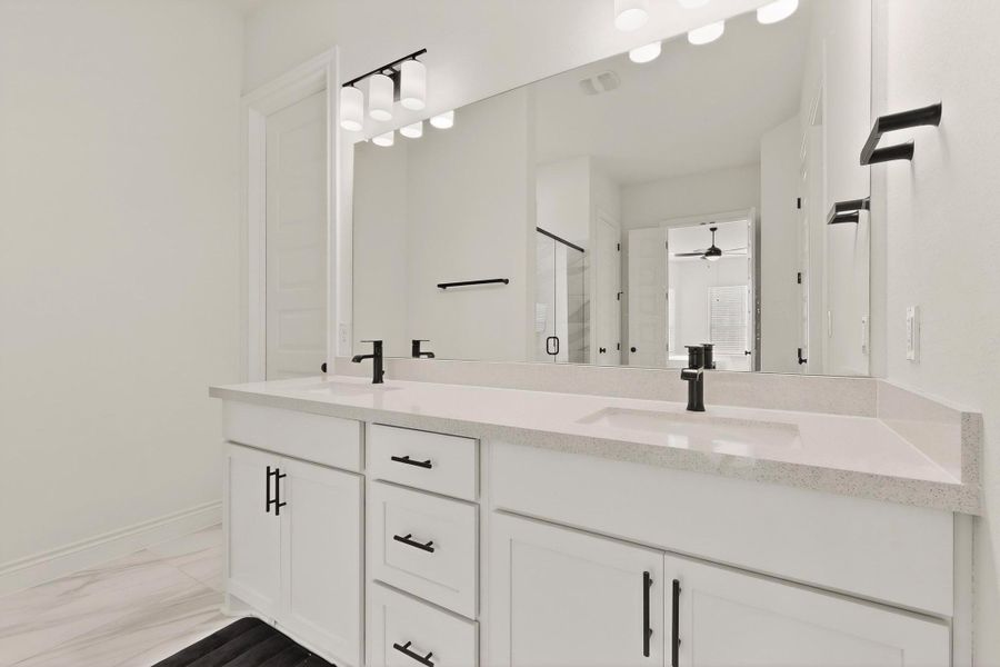 Bathroom with double vanity, a stall shower, and a ceiling fan