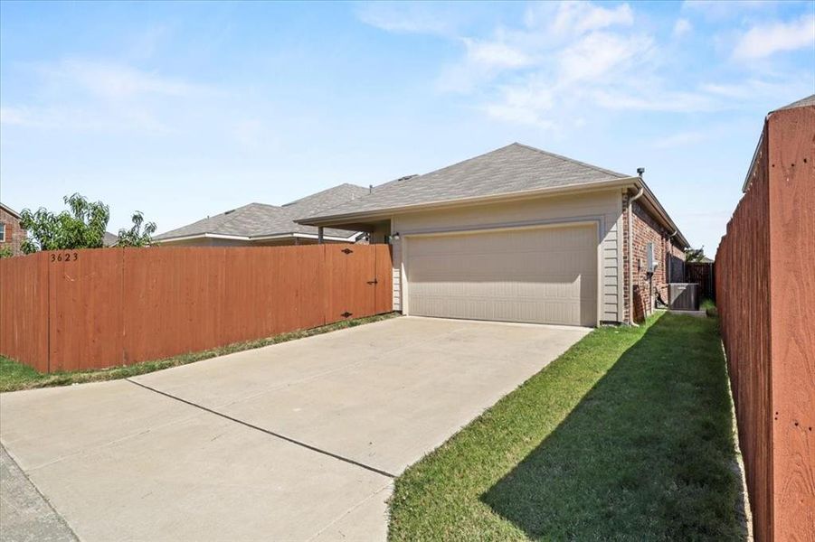 View of side of property featuring driveway, brick siding, an attached garage, and roof with shingles View of side of property featuring driveway, brick siding, an attached garage, and roof with shingles