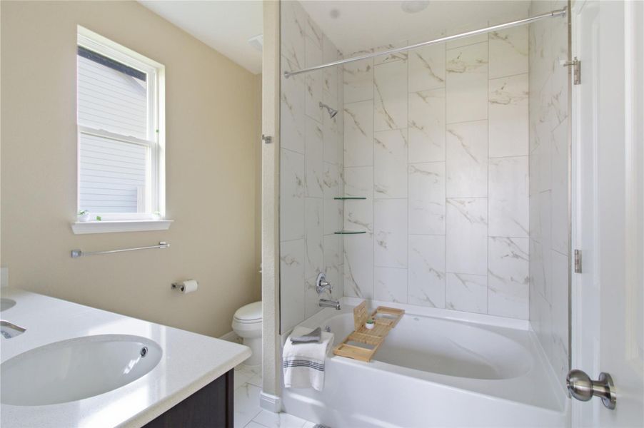 A well-appointed bathroom features a deep soaking tub with a tiled surround and an elegant vanity.