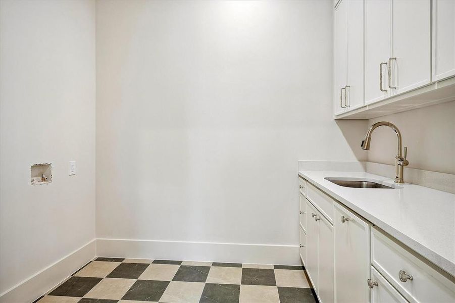 Second-floor laundry, built-in cabinetry, utility sink, stone countertop Second-floor laundry, built-in cabinetry, utility sink, stone countertop