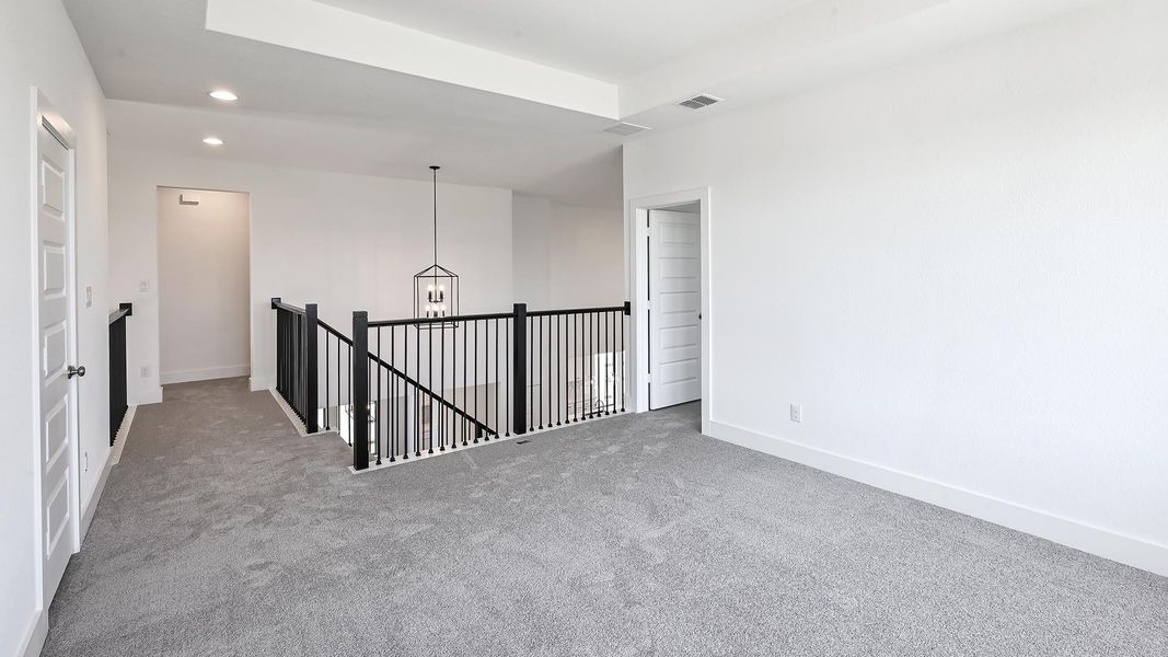 Carpeted empty room with recessed lighting and a chandelier