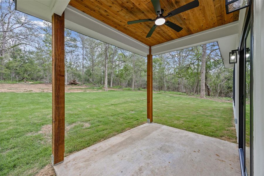 Covered patio with a concrete surface, wooden ceiling, and a ceiling fan Covered patio with a concrete surface, wooden ceiling, and a ceiling fan