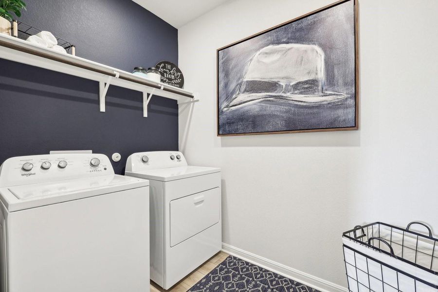 Functional laundry space featuring convenient shelving and essential appliances. Functional laundry space featuring convenient shelving and essential appliances.