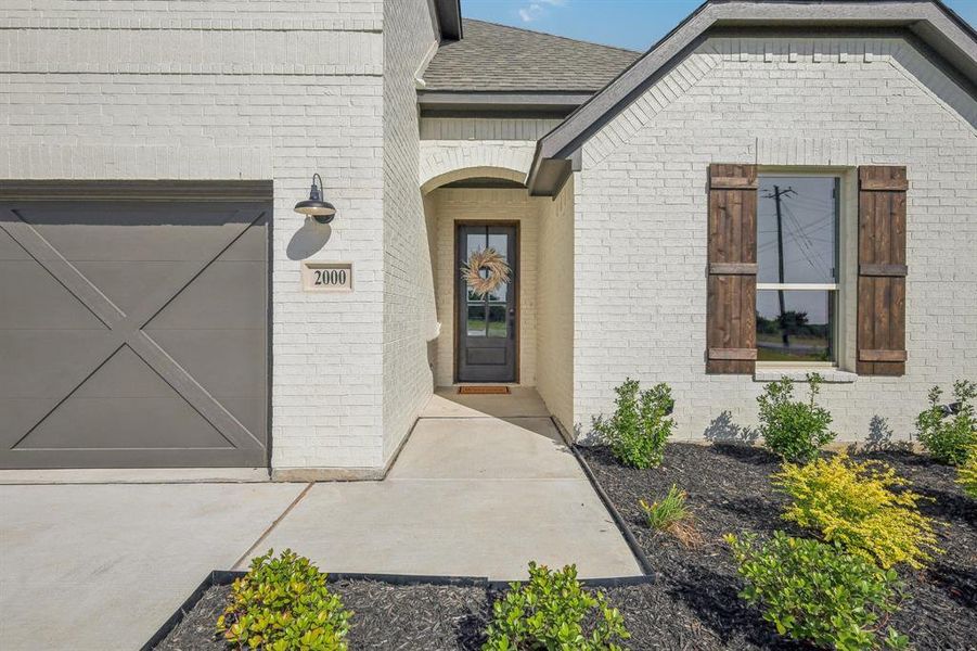 View of exterior entry with a garage