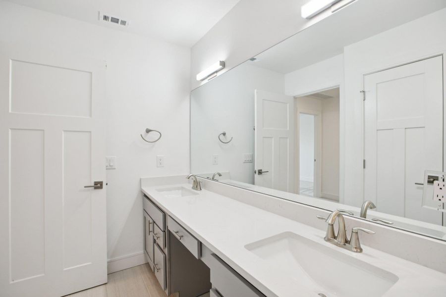 Bathroom featuring double vanity and baseboards