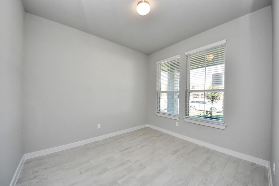 Step into the inviting home office, where elegant tile flooring adds a touch of freshness and comfort to the workspace. Natural light pours through the window, creating an inspiring environment for productivity and focus. Sample photo of completed home with similar floor plan. Actual colors and selections may vary.