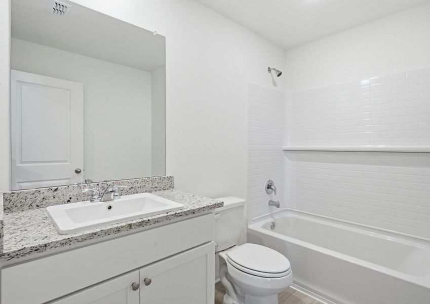 Secondary bathroom featuring a vanity with granite countertop and a tub/shower combination. Secondary bathroom featuring a vanity with granite countertop and a tub/shower combination.