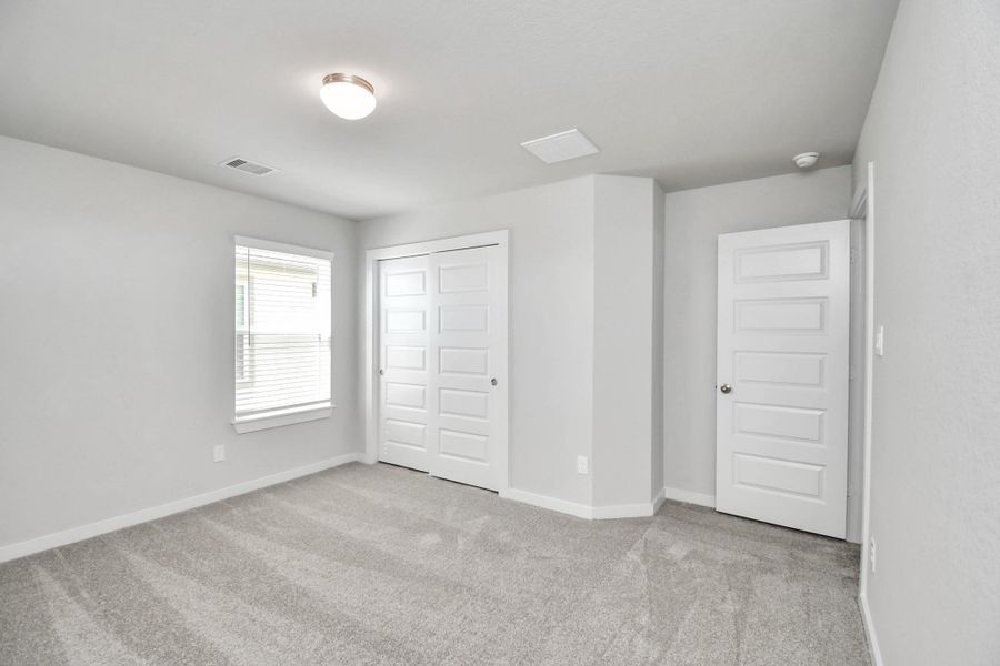 Generously sized secondary bedrooms featuring spacious closets, soft and inviting carpeting underfoot, large windows allowing plenty of natural light, and the added touch of privacy blinds for your personal retreat. Sample photo of completed home with similar floor plan. Actual colors and selections may vary.