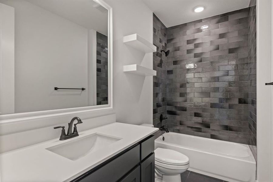 Bathroom featuring shower / tub combination, tile patterned flooring, vanity, and toilet