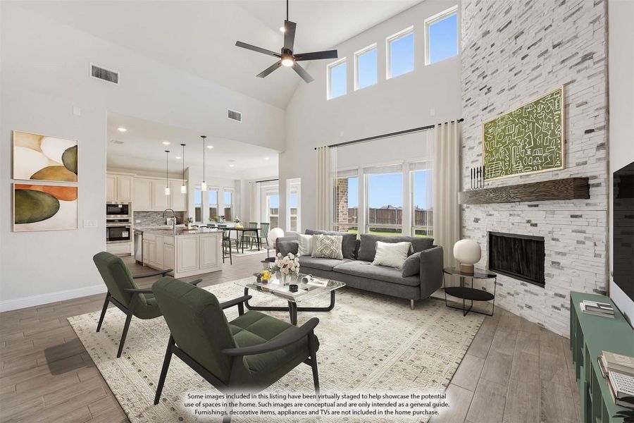 Open living room with vaulted ceiling, stone fireplace, and open-concept kitchen in background