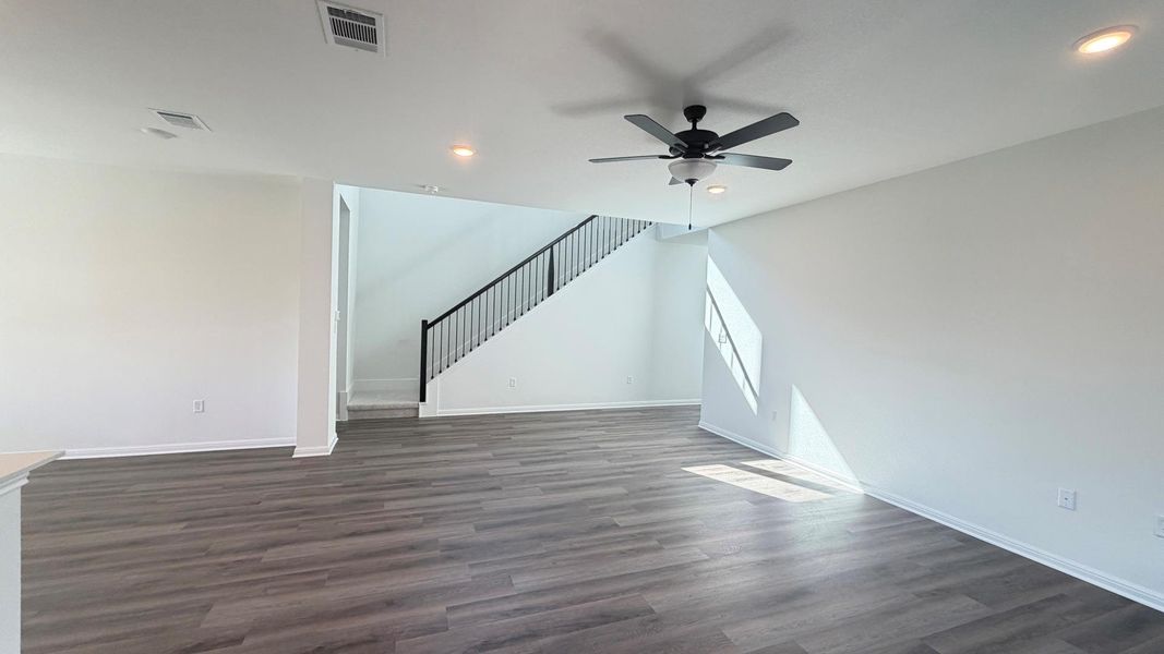 A well-lit interior space features sleek wood flooring and a modern staircase with dark railings, creating a sophisticated aesthetic. A well-lit interior space features sleek wood flooring and a modern staircase with dark railings, creating a sophisticated aesthetic.