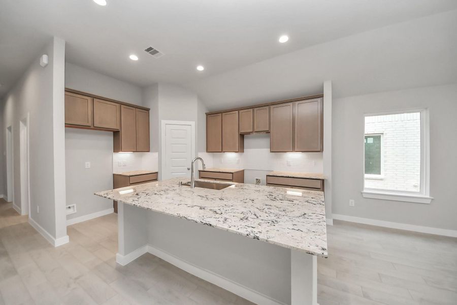 This kitchen offers both style and practicality. All this opens up to the expansive family room, creating a perfect hub for gatherings. Sample photo of completed home with similar floor plan. Actual colors and selections may vary.