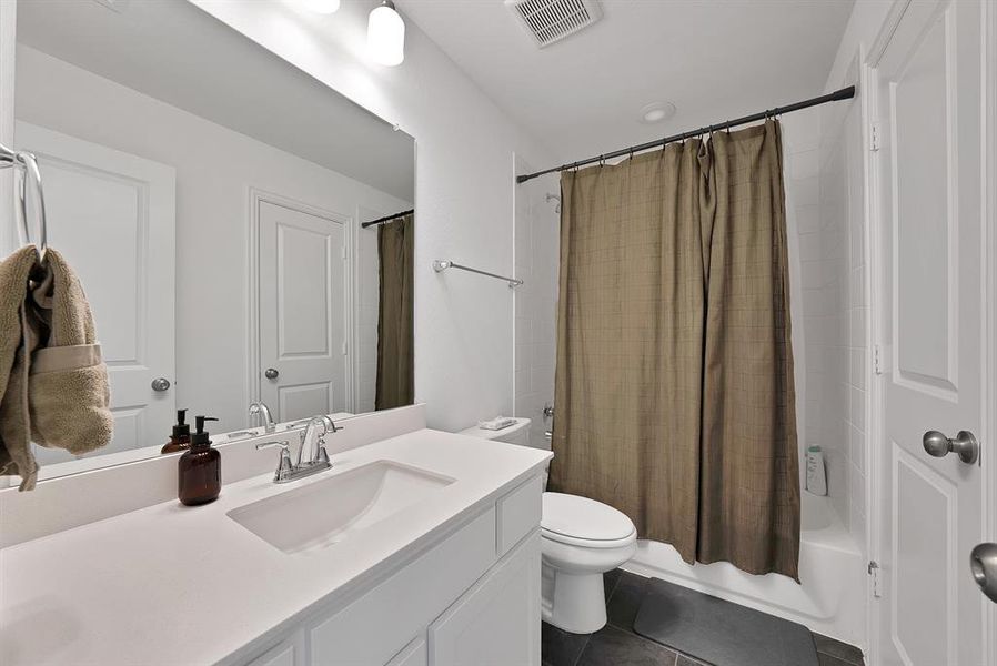 Bathroom vanity featuring an integrated sink, polished chrome faucet, and expansive wall mirror
