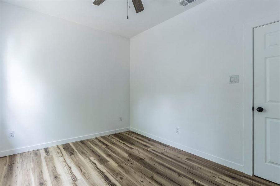 Unfurnished room with wood finished floors, ceiling fan, and baseboards Unfurnished room with wood finished floors, ceiling fan, and baseboards