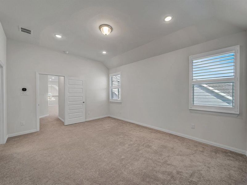 Unfurnished bedroom featuring lofted ceiling and light carpet