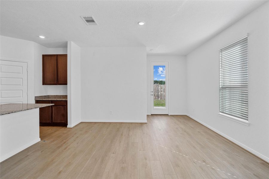 Start your day with a warm cup of coffee and quality time in this charming dining area! Highlights include a large window, custom neutral paint, vinyl plank flooring, recessed lighting, high ceilings, and a convenient door leading to the rear patio and backyard. Start your day with a warm cup of coffee and quality time in this charming dining area! Highlights include a large window, custom neutral paint, vinyl plank flooring, recessed lighting, high ceilings, and a convenient door leading to the rear patio and backyard.