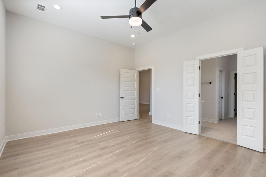 Recessed lighting, ceiling fan, wood-finish flooring, white paneled doors, and high ceilings Recessed lighting, ceiling fan, wood-finish flooring, white paneled doors, and high ceilings