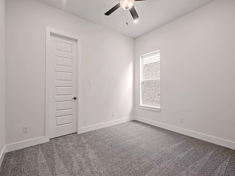 Secondary bedroom with carpet flooring and ceiling fan.