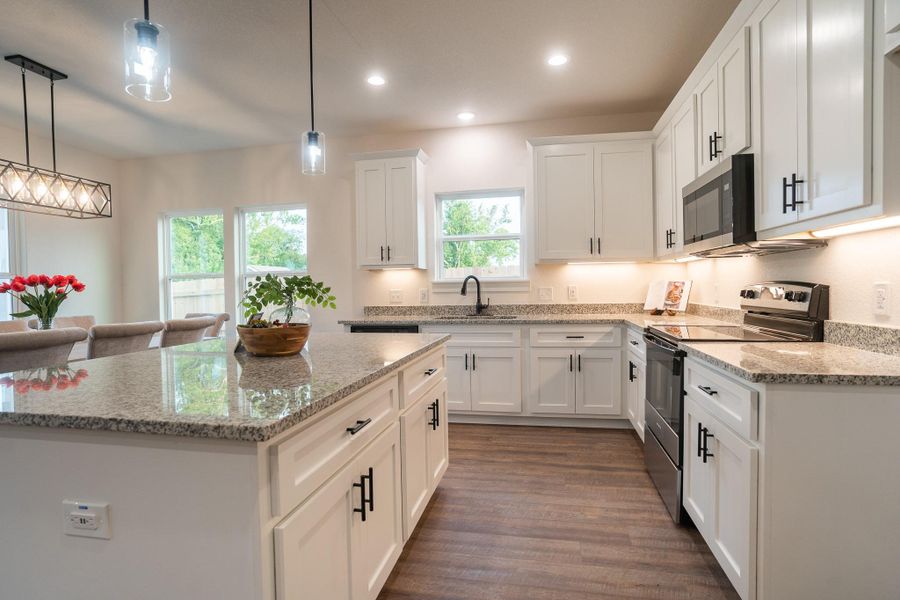 Kitchen featuring stainless steel appliances, healthy amount of natural light, white cabinets, a center island, and recessed lighting