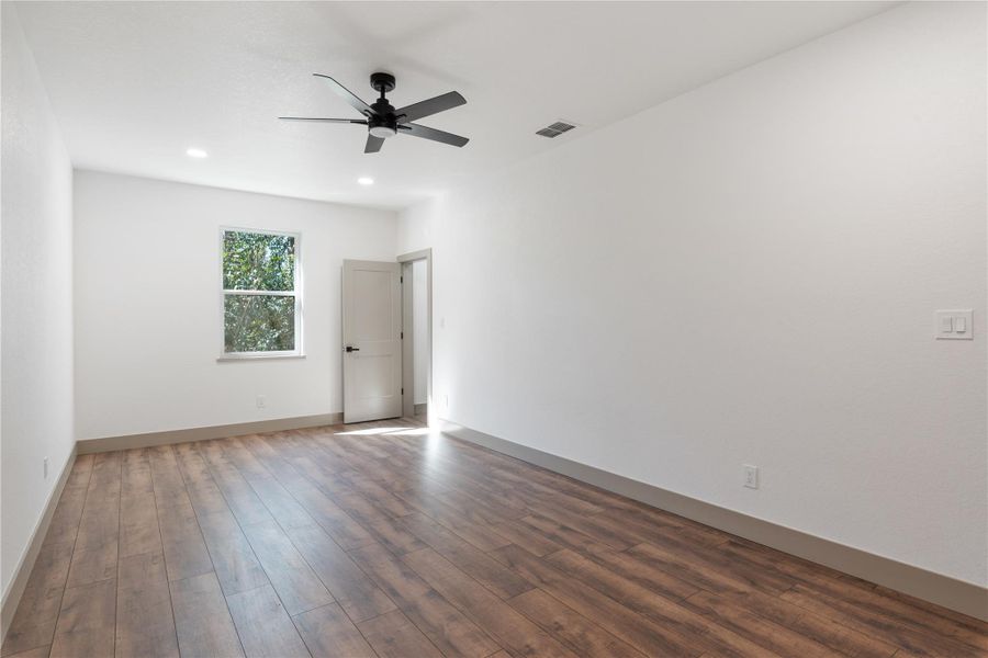 Spare room with a ceiling fan, wood finished floors, visible vents, baseboards, and recessed lighting