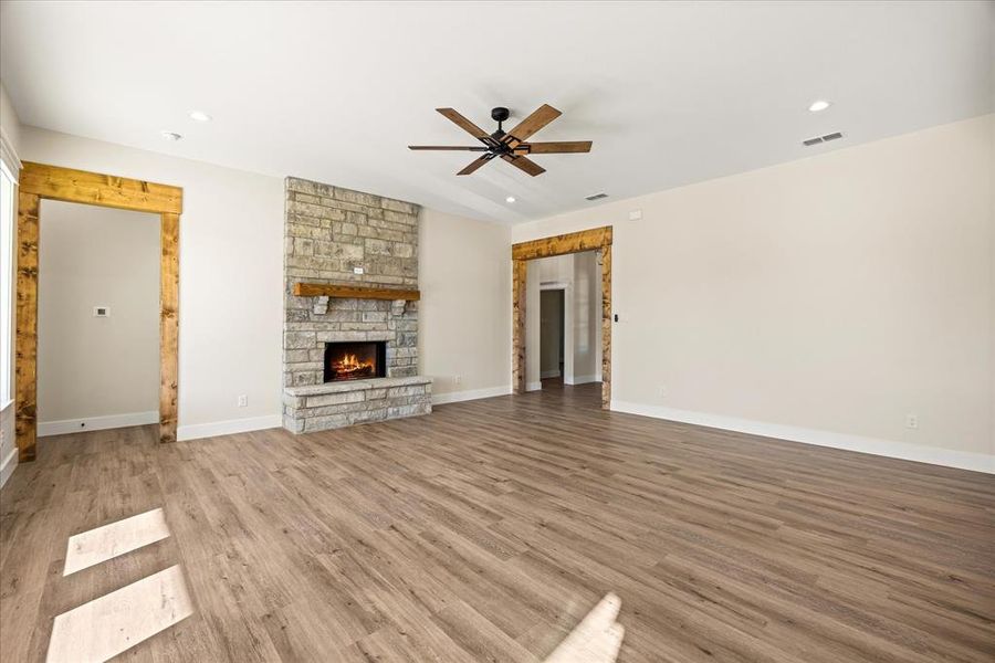 Living room featuring wood finished floors, a fireplace, recessed lighting, and ceiling fan