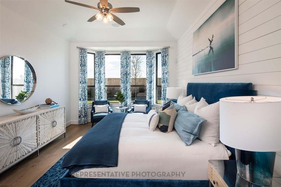 Bedroom with wood finished floors, ceiling fan, and wooden walls Bedroom with wood finished floors, ceiling fan, and wooden walls