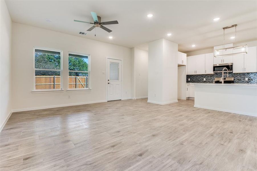 Unfurnished living room with light wood-style floors, recessed lighting, and a ceiling fan