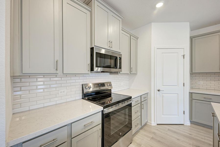 Culinary creations come to life in this kitchen, boasting pristine countertops and modern appliances.