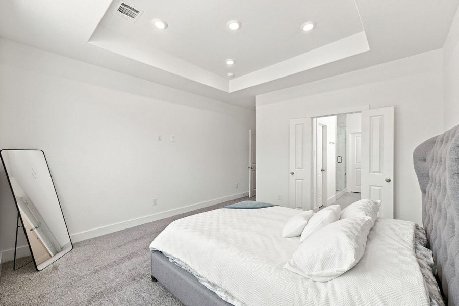 Primary suite offering generous space, a stylish tray ceiling with recessed lighting, and convenient direct access to the ensuite bathroom and walk-in closet. Primary suite offering generous space, a stylish tray ceiling with recessed lighting, and convenient direct access to the ensuite bathroom and walk-in closet.