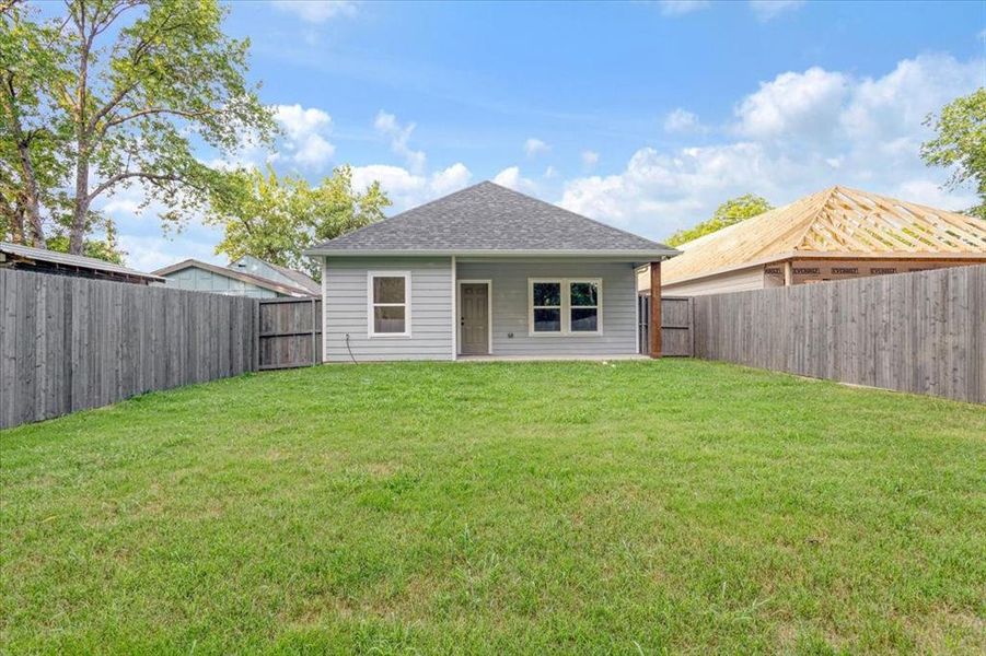 Back of house with a yard