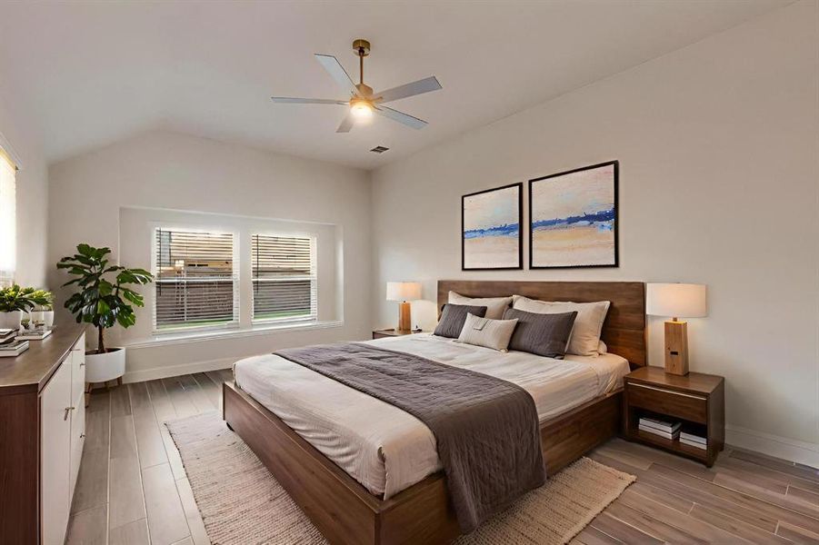Bedroom featuring wood finished floors, a ceiling fan, and lofted ceiling