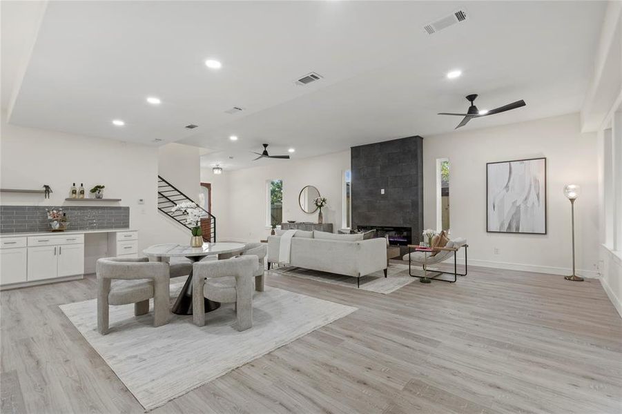 Dining space with ceiling fan, light wood-style floors, stairs, recessed lighting, and a bar Dining space with ceiling fan, light wood-style floors, stairs, recessed lighting, and a bar