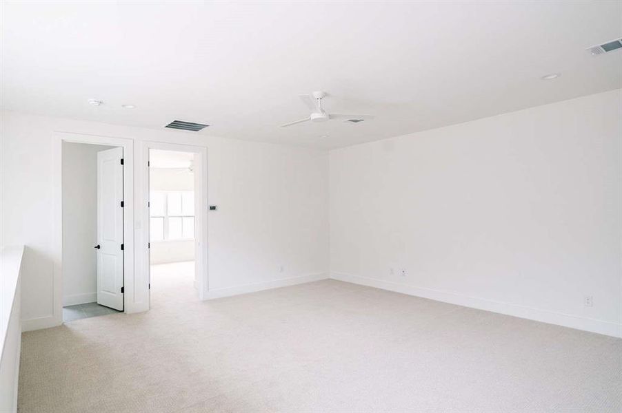 Spare room featuring ceiling fan and light carpet