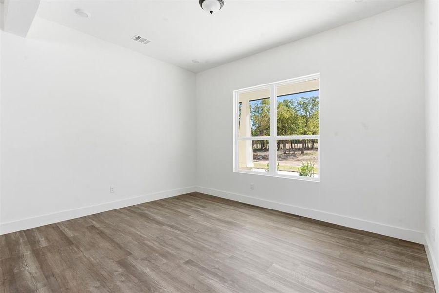 Empty room with light wood-style flooring and baseboards Empty room with light wood-style flooring and baseboards