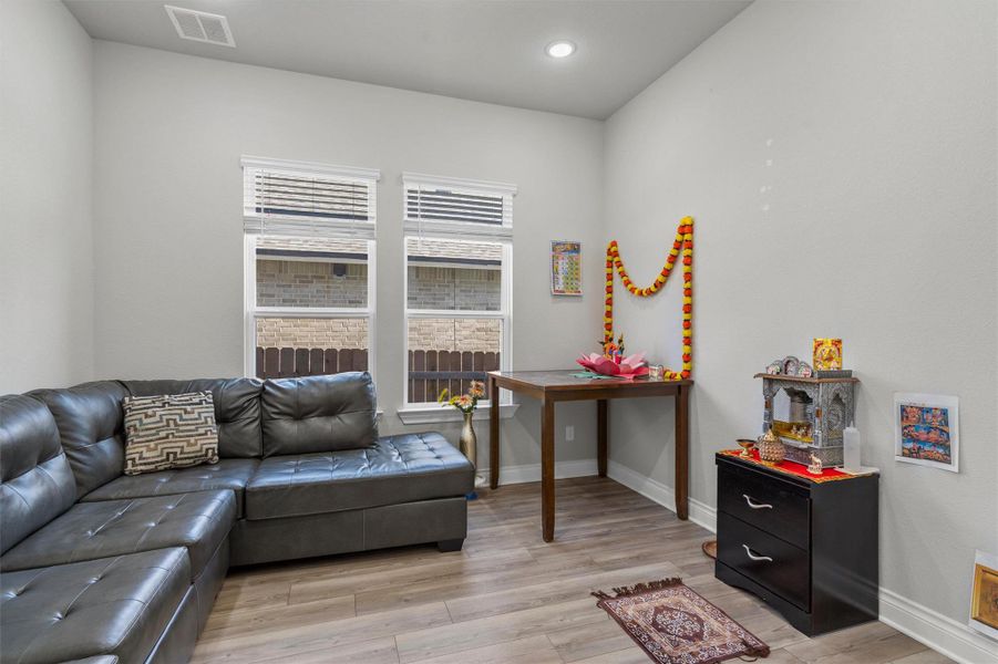 Natural light streams through double windows onto durable wood-look flooring.