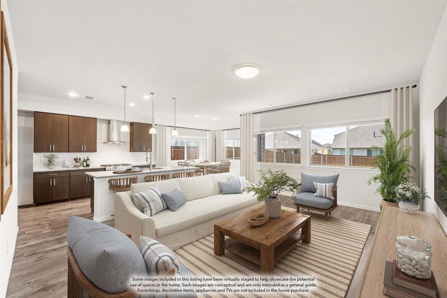 Open-concept living room and kitchen with hardwood floors, white sofa, and dark wood cabinets