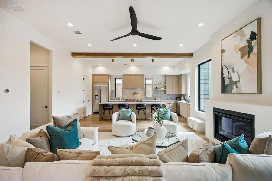 Living room – flows seamlessly into the kitchen area and features a ceiling fan, recessed lighting, and an exposed wood beam. Living room – flows seamlessly into the kitchen area and features a ceiling fan, recessed lighting, and an exposed wood beam.