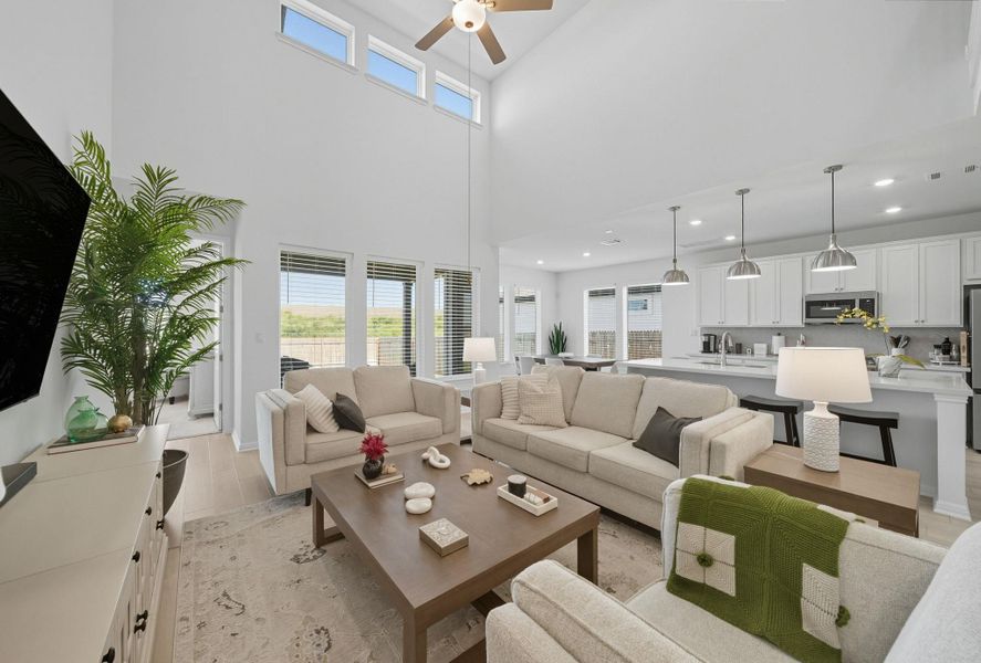 Living area featuring light wood finished floors, a ceiling fan, a towering ceiling, and recessed lighting Living area featuring light wood finished floors, a ceiling fan, a towering ceiling, and recessed lighting