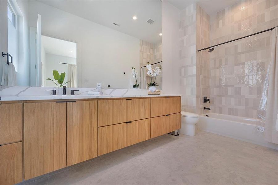 Full bathroom with toilet, vanity, and shower / tub combo