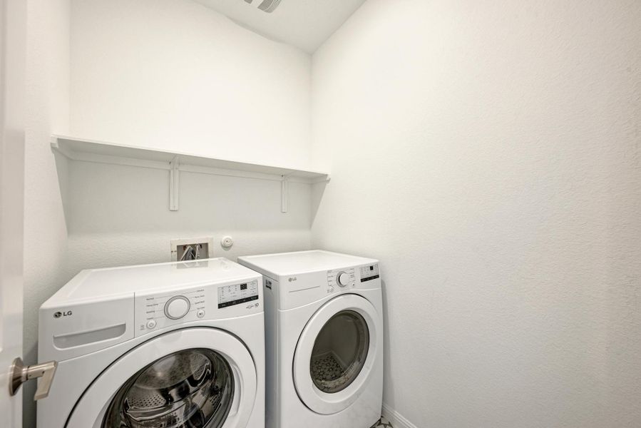 A dedicated laundry room with modern appliances and practical shelving offers ultimate convenience.