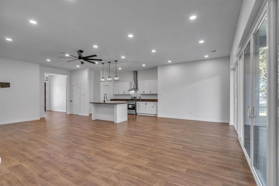 Unfurnished living room featuring light wood-type flooring, sink, and ceiling fan